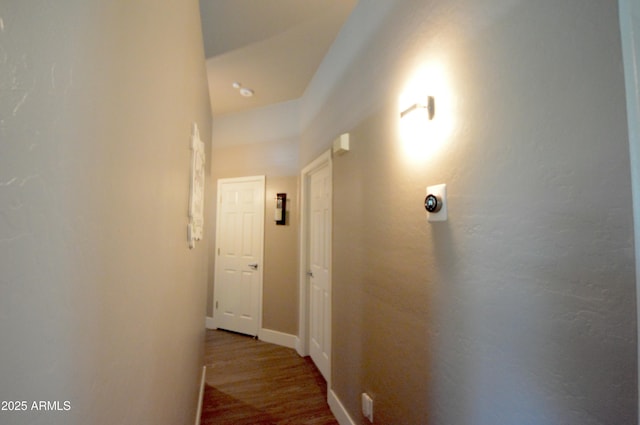 corridor with wood finished floors and baseboards