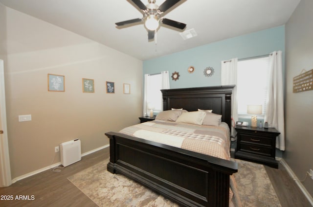 bedroom featuring visible vents, baseboards, ceiling fan, and wood finished floors