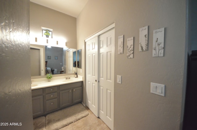 ensuite bathroom featuring double vanity, a sink, connected bathroom, and tile patterned floors