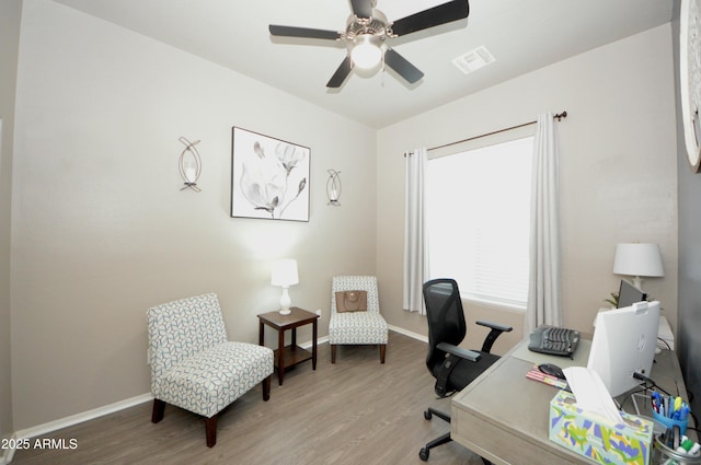 office with light wood-style floors, baseboards, visible vents, and a ceiling fan