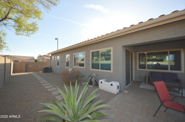 back of house featuring a patio, a fenced backyard, cooling unit, and stucco siding