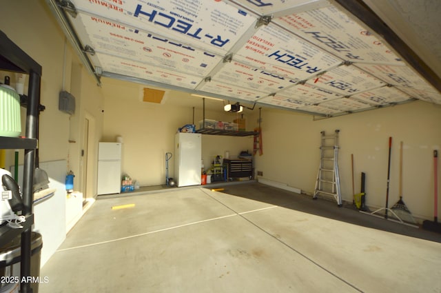 garage with a garage door opener and freestanding refrigerator