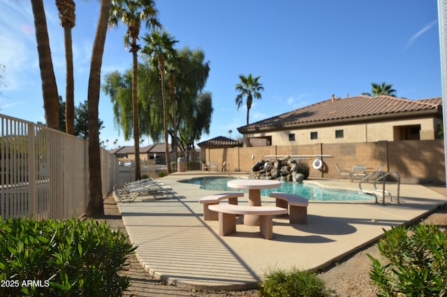 community pool featuring a fenced backyard and a patio