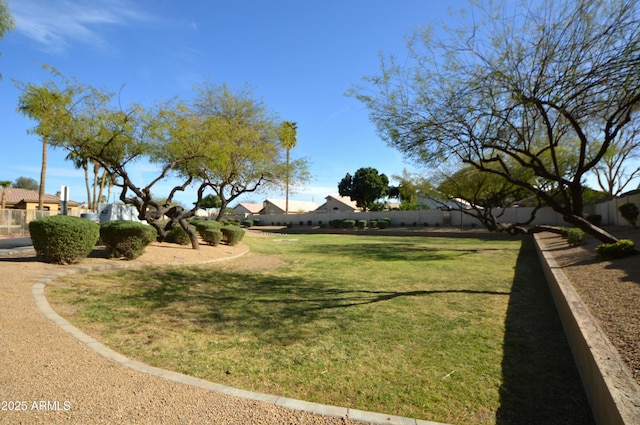 view of community featuring a yard and fence