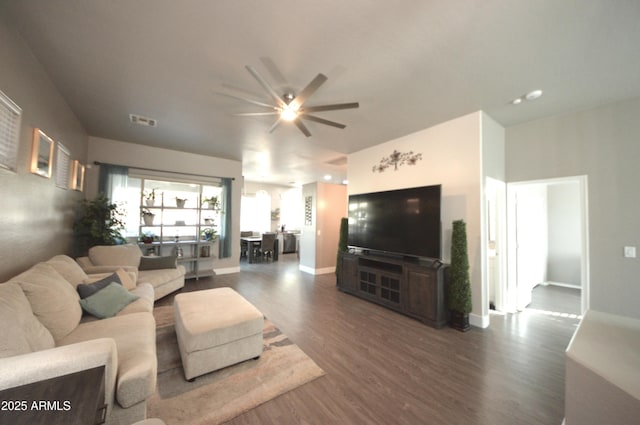 living area with ceiling fan, wood finished floors, visible vents, and baseboards