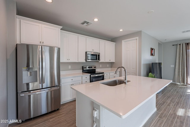 kitchen featuring a kitchen island with sink, sink, white cabinetry, and stainless steel appliances