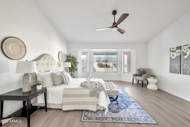 bedroom featuring a ceiling fan, baseboards, vaulted ceiling, and wood finished floors