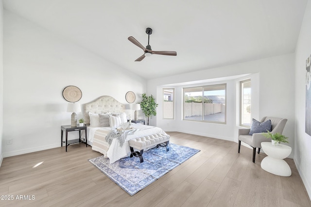 bedroom featuring a ceiling fan, vaulted ceiling, baseboards, and wood finished floors