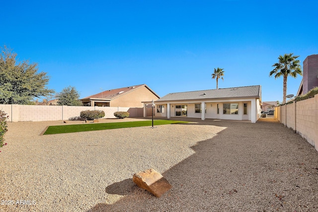 back of property featuring stucco siding, a fenced backyard, a yard, and a patio