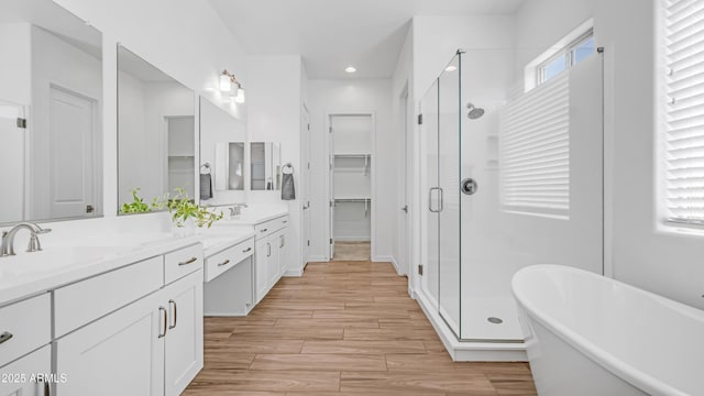 8140 E June St, Mesa, AZ 85207 - bathroom featuring a stall shower, double vanity, a freestanding bath, recessed lighting, and wood finished floors