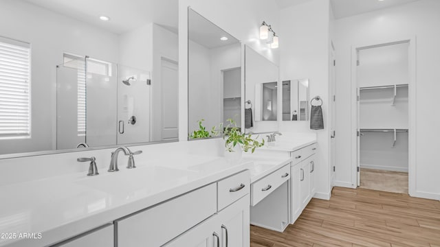 8140 E June St, Mesa, AZ 85207 - bathroom featuring a stall shower, double vanity, a spacious closet, wood finished floors, and recessed lighting
