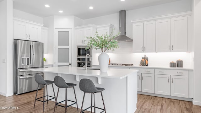 8140 E June St, Mesa, AZ 85207 - kitchen with appliances with stainless steel finishes, wall chimney exhaust hood, a center island with sink, a breakfast bar, and backsplash