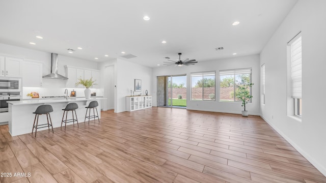 8140 E June St, Mesa, AZ 85207 - unfurnished living room featuring a ceiling fan, light wood finished floors, and recessed lighting