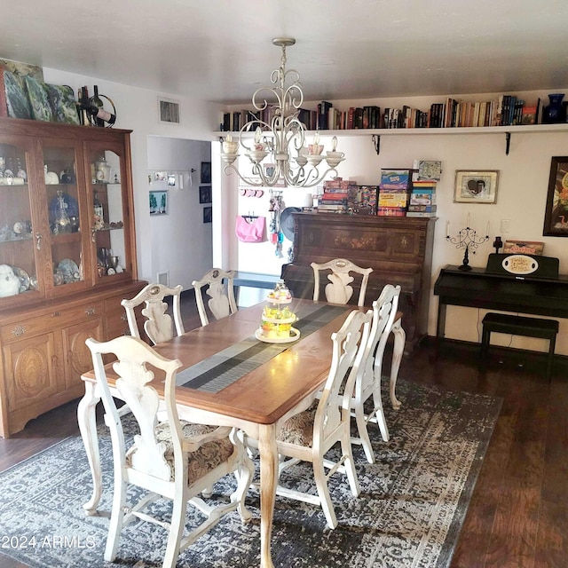 dining area featuring visible vents, an inviting chandelier, and wood finished floors