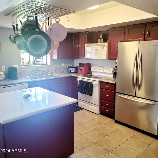 kitchen featuring light tile patterned flooring, white appliances, light countertops, and a sink