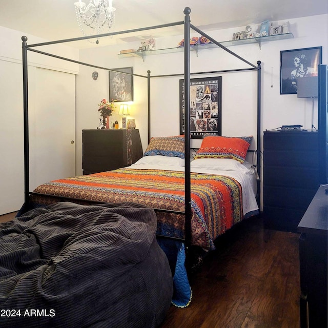 bedroom with an inviting chandelier and wood finished floors