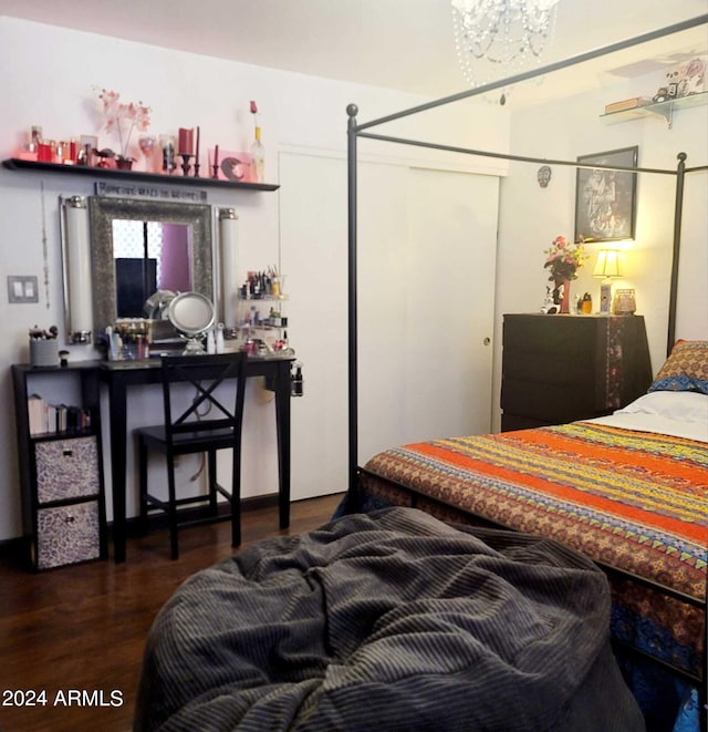 bedroom featuring a notable chandelier and wood finished floors