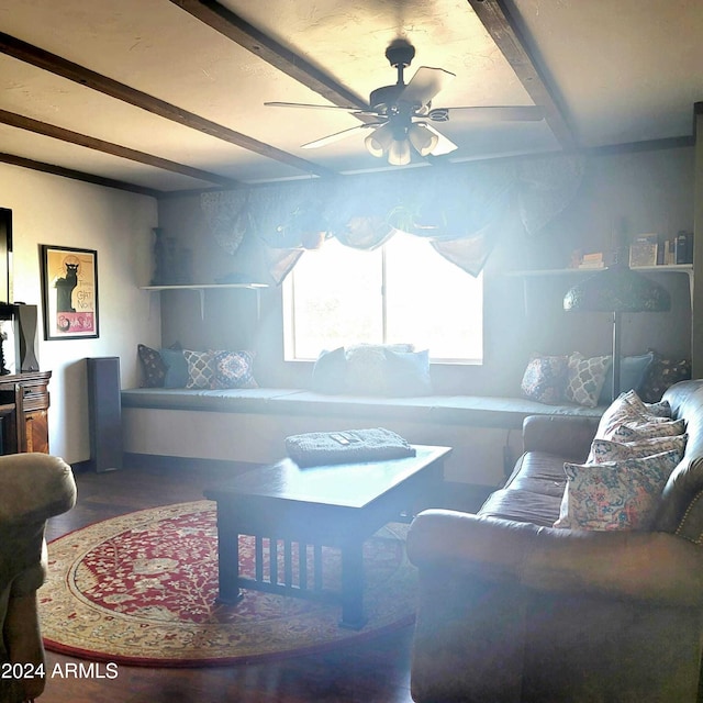 living area featuring beam ceiling and ceiling fan