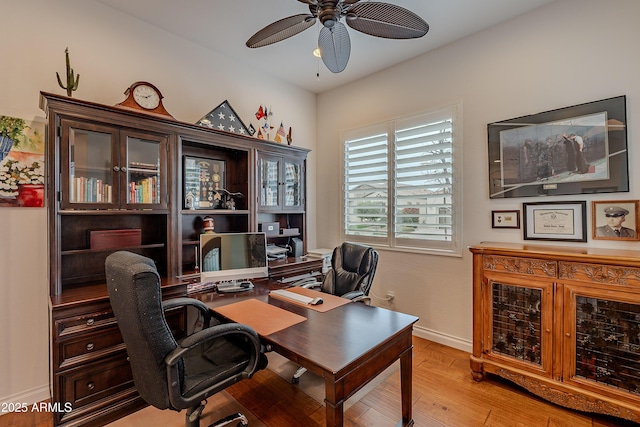 office space featuring light wood-type flooring, baseboards, and a ceiling fan