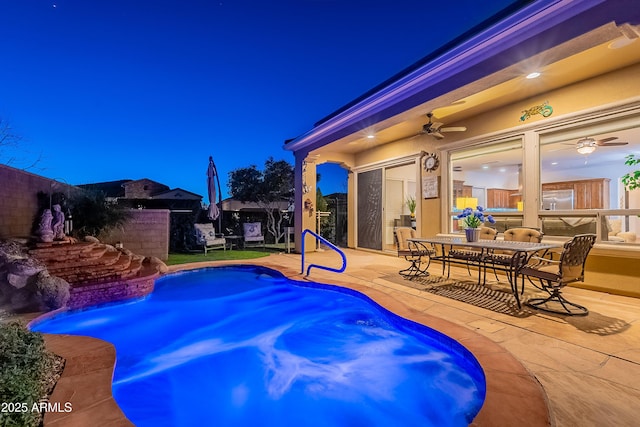 pool at twilight featuring a ceiling fan, outdoor dining space, a fenced backyard, and a patio