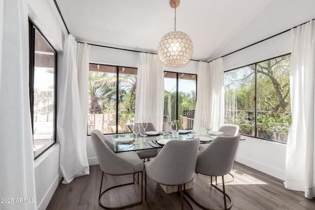 dining space with vaulted ceiling, wood finished floors, and baseboards