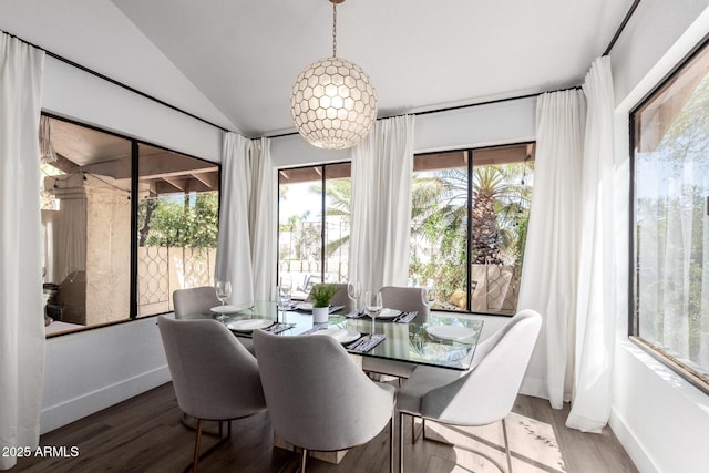 dining area featuring baseboards, wood finished floors, and vaulted ceiling