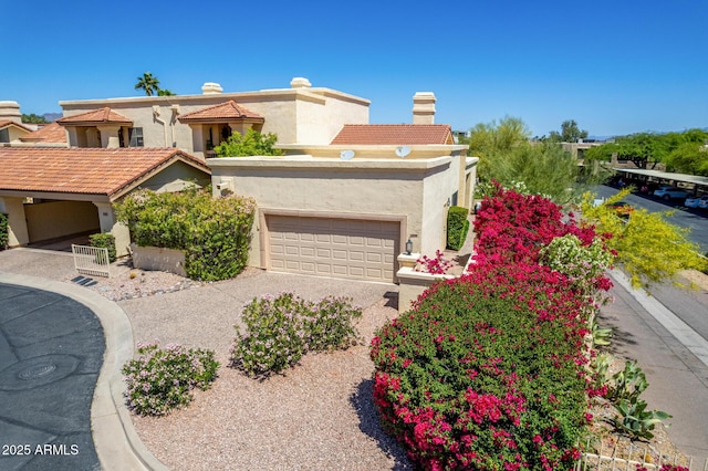 view of front of home with a garage, a chimney, stucco siding, and driveway