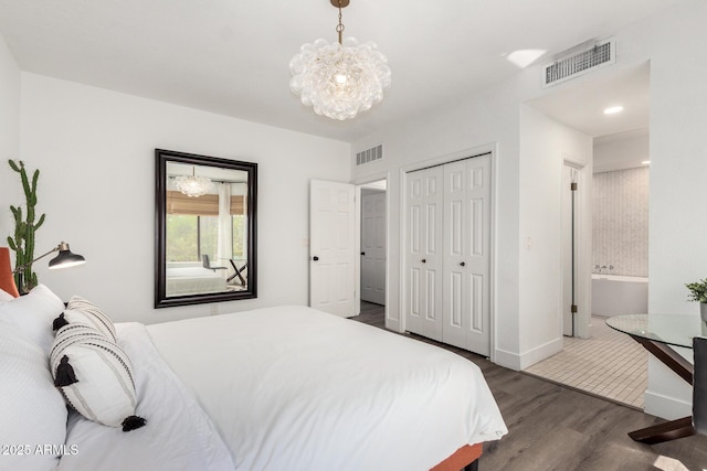 bedroom featuring dark wood finished floors, visible vents, an inviting chandelier, and a closet