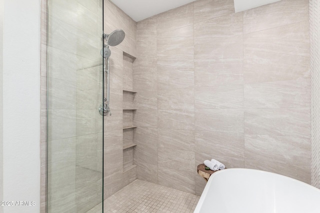 bathroom featuring a freestanding tub and tiled shower