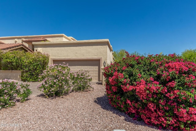view of home's exterior with stucco siding and an attached garage