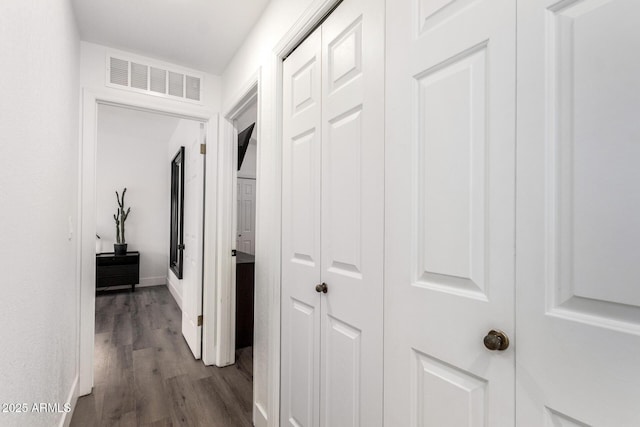 corridor with dark wood-style floors and visible vents