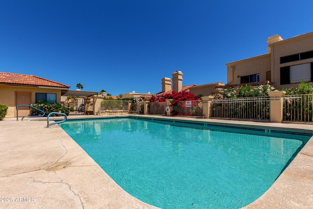 community pool featuring fence and a patio