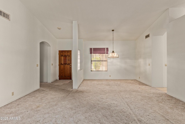 spare room with arched walkways, carpet, and visible vents