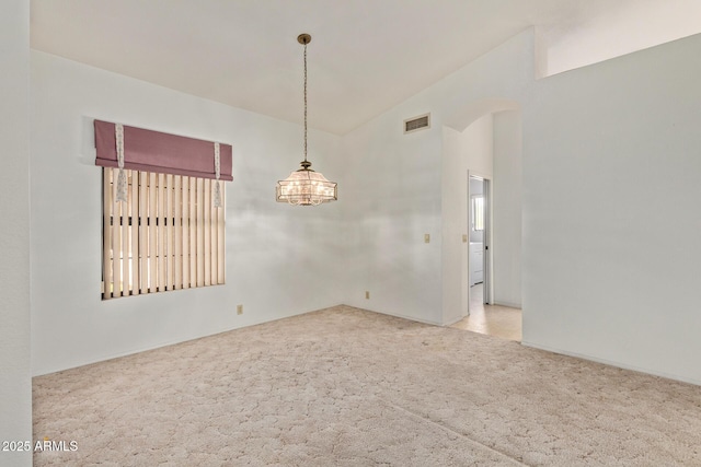 carpeted empty room with visible vents, arched walkways, lofted ceiling, and a notable chandelier