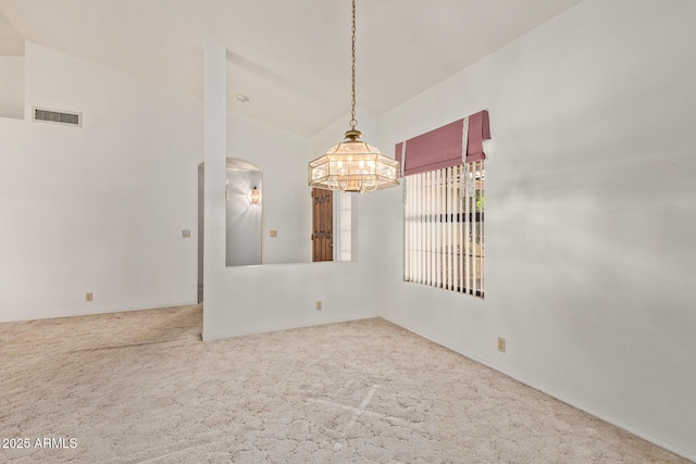 unfurnished room featuring visible vents, carpet flooring, arched walkways, and an inviting chandelier
