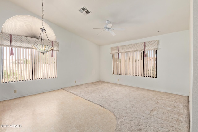 empty room with carpet flooring, ceiling fan, visible vents, and vaulted ceiling