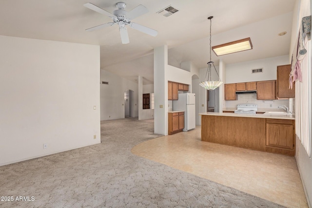 kitchen featuring white appliances, brown cabinets, open floor plan, and visible vents