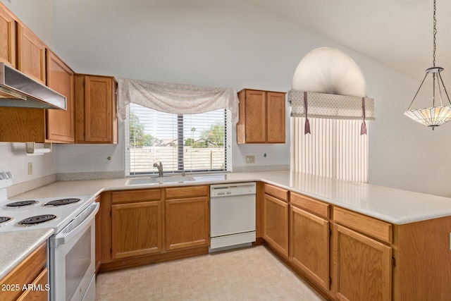 kitchen featuring vaulted ceiling, a sink, light countertops, a peninsula, and white appliances