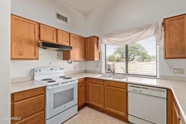 kitchen with visible vents, decorative backsplash, white appliances, under cabinet range hood, and a sink