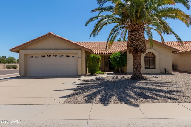view of front of home featuring a garage, stucco siding, a tile roof, and concrete driveway