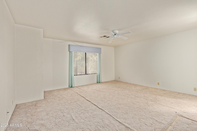 empty room featuring carpet floors, ceiling fan, and visible vents