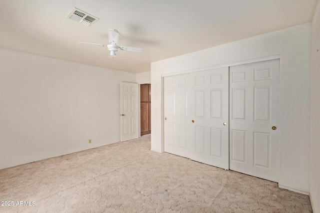 unfurnished bedroom with ceiling fan, carpet, a closet, and visible vents