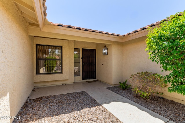 view of exterior entry with stucco siding
