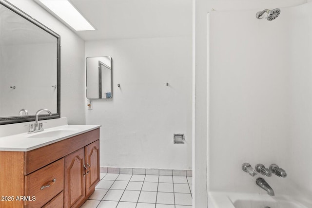 bathroom featuring a skylight, tile patterned flooring, bathing tub / shower combination, and vanity