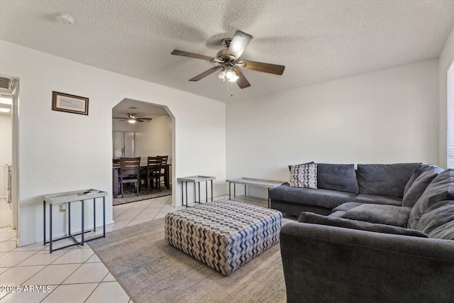 living room featuring ceiling fan, a textured ceiling, and light tile patterned floors