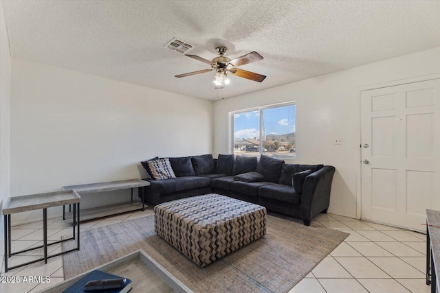 living room featuring ceiling fan, a textured ceiling, and light tile patterned floors