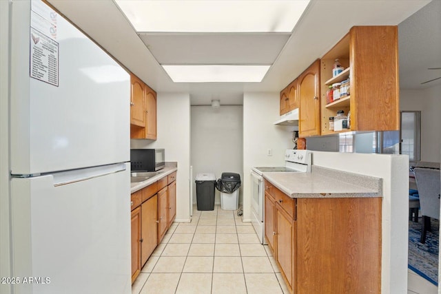 kitchen featuring light tile patterned floors and white appliances