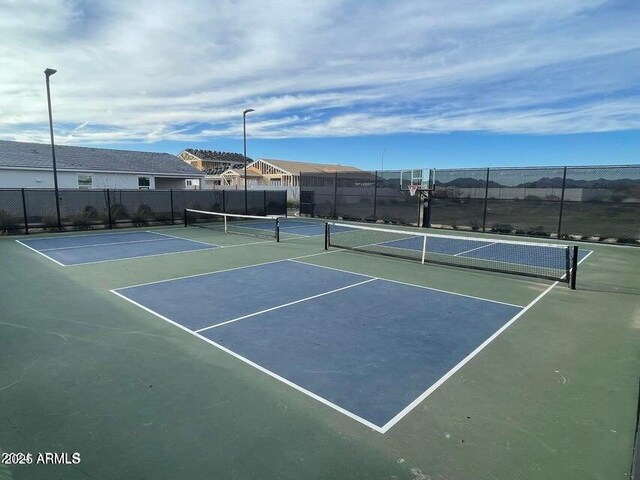 view of tennis court with basketball hoop