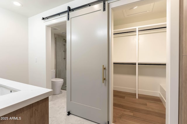 bathroom featuring toilet, wood-type flooring, vanity, and walk in shower