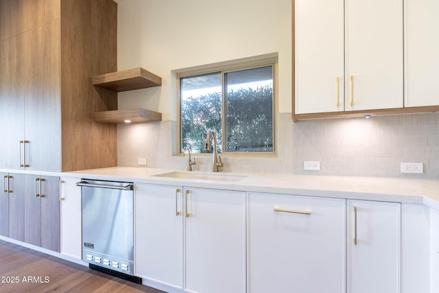 kitchen with sink, white cabinetry, and dishwasher